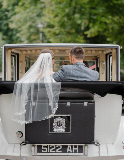 Bride and groom leave in their classic wedding car